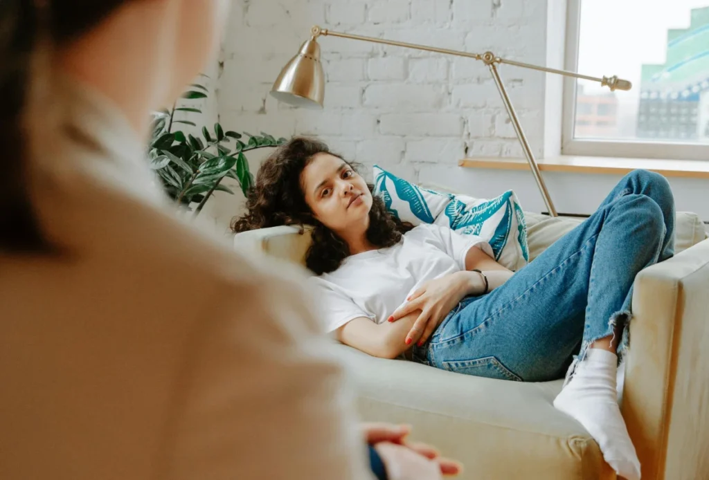 Individual lying comfortably on a couch, representing therapeutic relaxation and healing.